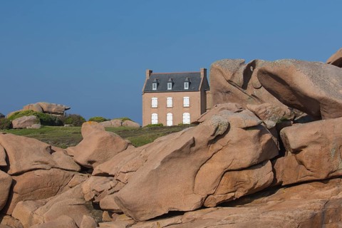 Old house next to Lighthouse Mean Ruz at Ploumanach, Cotes d'Armor in the evening light