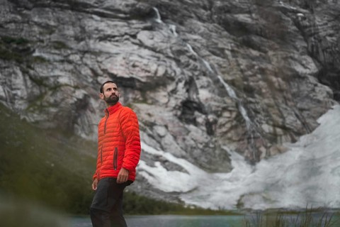 A man in a red jacket explores the stunning mountainous landscapes of Norway Perfect moment