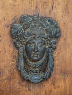 Door knocker as a human face in Urbino, Marche, Italy