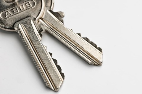 Close-up of two keys of a cylinder lock, white background
