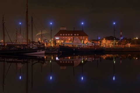 View over the new harbour to a restaurant in Bremerhaven at night, Bremerhaven, Bremen, Germany