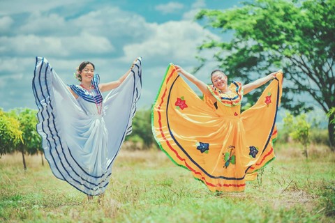Women wearing traditional Nicaraguan folk costume in a field. Portrait of smiling girls in national