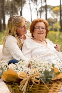 An adult daughter lovingly embraces her elderly mother as they spend quality time together