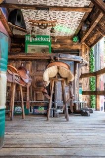 Wooden bar with bar stools decorated with saddles