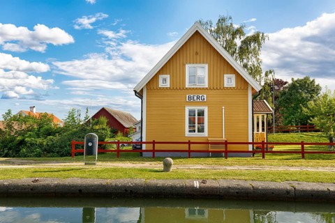 Charming yellow wooden house, lock keeper's house, sign with inscription, lock stairs near