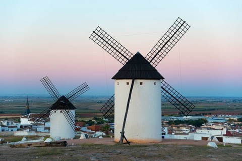Windmills in a village at sunrise with pink sky, Campo de Criptana, Ciudad Real province,