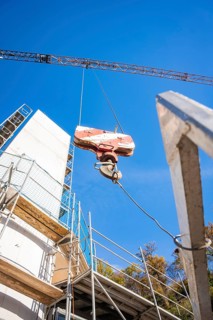 Detailed view of a crane and structures on a construction site in front of a blue sky, ZOB Calw