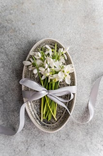 Top view of a charming display of fresh spring snowdrops artfully arranged in a vintage decorative