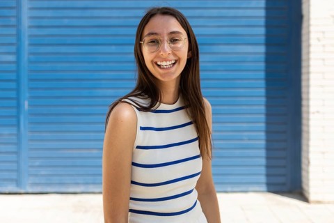A woman enjoys the city life, embracing the outdoors with a cheerful smile. Her casual attire and