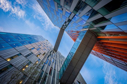 Dynamic perspective of futuristic buildings from Google and bridges under a cloudy sky, Docklands