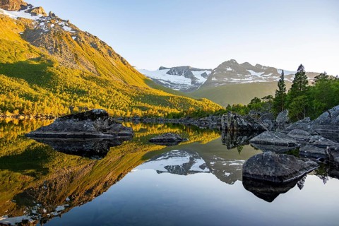 Picturesque mountain landscape in the Innerdalen high valley, mountain peaks reflected in Lake
