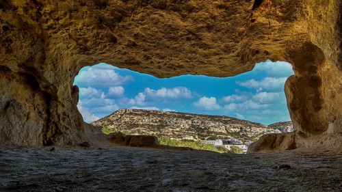 Sky changed, Neolithic caves, former hippie paradise, cave with window view of rocky landscape