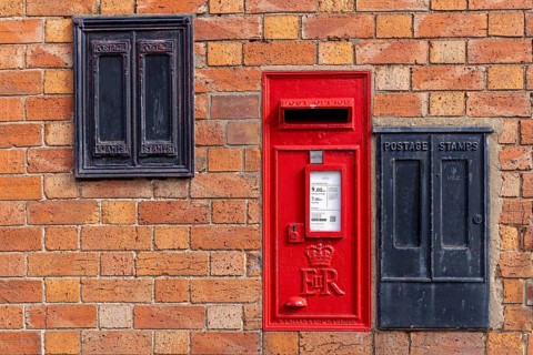 Traditional red mailbox, former stamp vending machines, house wall, Bretforton, The Cotswolds,