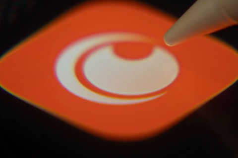 Dhaka, Bangladesh- 06 Dec 2025: Close-up of the Crunchyroll app on a screen with a stylus pointing