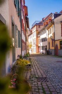 Idyllic old town alleyway with cobblestones and colorful houses in sunlight, Bregenz, Austria