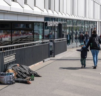 Little child holding mother's arm points at a sleeping homeless person, Hugo Preuß Brücke, Berlin,