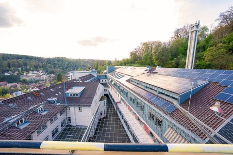 Hospital roof with solar panels surrounded by hilly landscape, old disused hospital, Calw, Germany