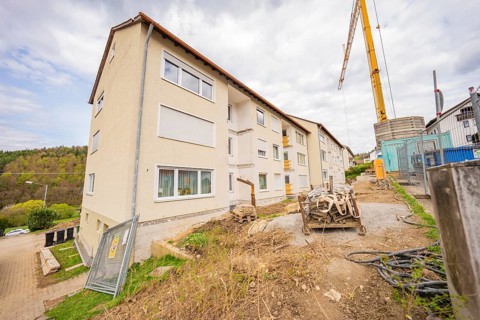 Multi-storey residential building in a suburban area with construction cranes and construction in