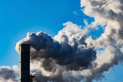 Smoke flows from a factory chimney against a blue sky, air pollution, industry, climate protection,