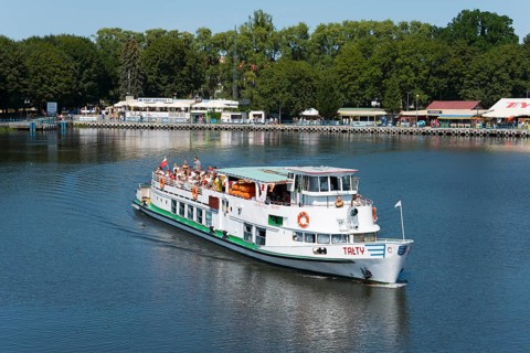 A passenger ship sails through calm waters, surrounded by green trees, ship Talty, harbour,