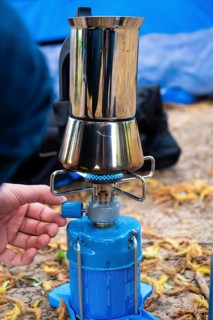 One person makes espresso on a camping cooker