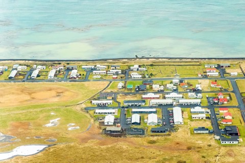 An aerial image showcasing a quaint village by the sea near Reikiavik, Iceland, with distinct