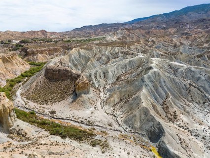 Breathtaking rock formations and deeply carved gorges in an arid landscape, aerial view, Tabernas