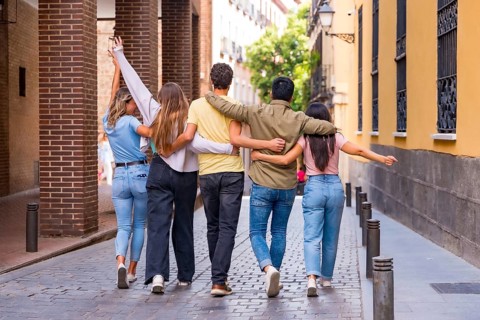 Group of multiracial friends hugging from behind in the city, friendship concept with boys and