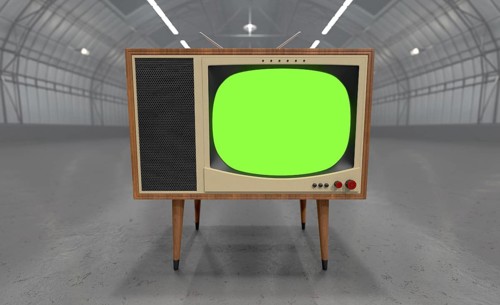 Vintage television with chroma green screen resting in the middle of an empty warehouse