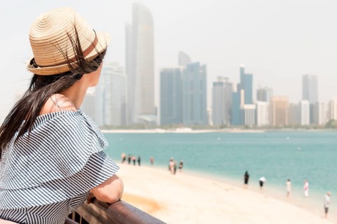 Woman tourist on viewpoint admire picturesque panorama of sandy turquoise water beach with tourist