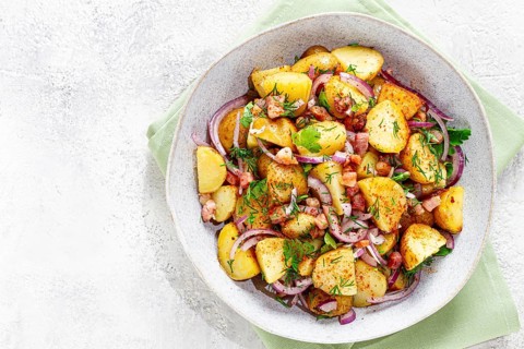 German potato salad, with bacon, onion and herbs, served in a bowl, homemade, no people