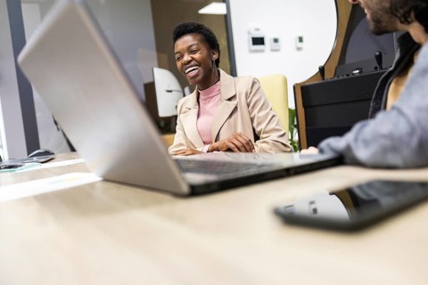 A lively and engaging office scene, showcasing smiling professionals collaborating in a modern