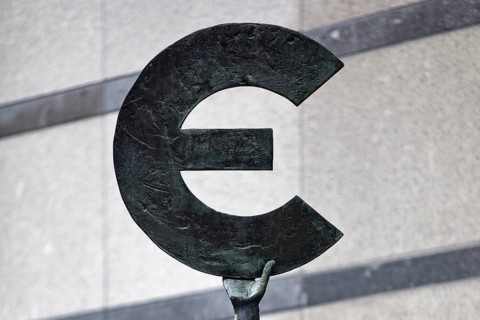 The bronze statue entitled Europe by May Claerhout holds up the euro symbol, detail with hand,