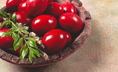 Painted eggs in a wooden bowl, red, painted madder dye, powder from the roots of endro, with onion