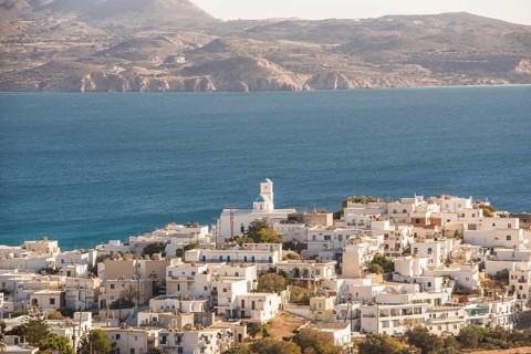 Aerial view of Adamas village on Milos Island, Greece. The scene captures white buildings, a
