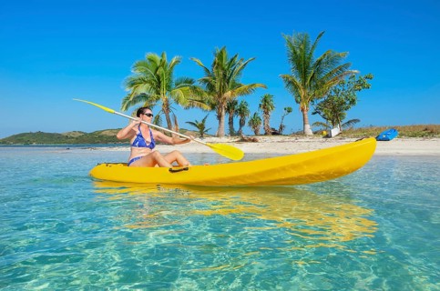 Woman sea kayaking in Fiji islands turquoise water, Waya island, Yasawa islands, Fiji