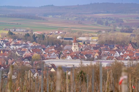 Panorama of a rural area with a church and red roofs under a cloudy sky, Großbottwar, Ludwigsburg