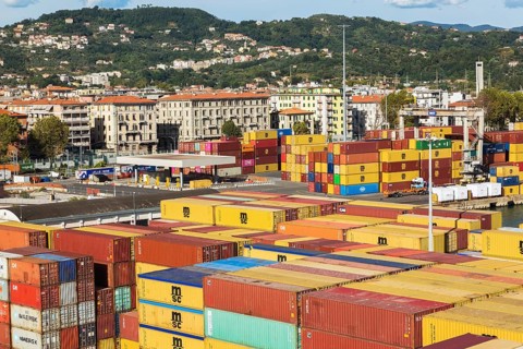 High angle view of rows of stacked rectangular metal box shipping containers on dock in La Spezia