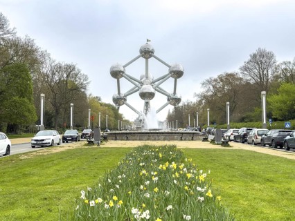The Atomium with blooming yellow daffodils on a green area in the foreground, Brussels, Belgium