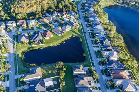 Aerial view of a new housing estate with houses on the lake in Wyndham Lakes, Orlando, USA