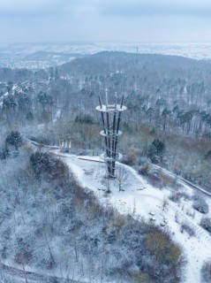 An observation tower in a snowy forest on a hill under a cloudy sky, Schönbuchturm, Herrenberg,