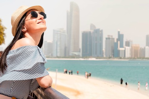 Happy young female tourist on viewpoint in hot day visiting Abu dhabi, UAE - Traveler girl taking