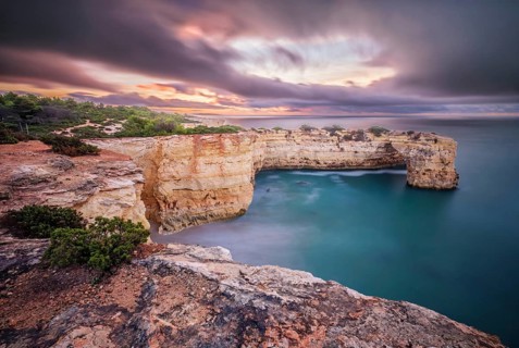 Long exposure sunrise at Praia de Albandeira beach in Algarve, Portugal, with Arco de Albandeira,