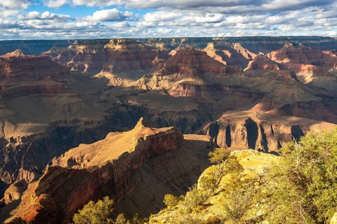 Grand canyon national park vista showing layered red rock formations and a deep sunlit gorge under
