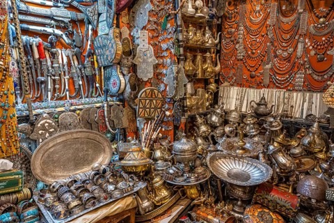 Brass plates, teapots knives and jewelry, necklaces on display in a shop for sale, Souk Bazaar,
