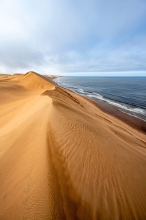 Sand dunes and sea in morning light, Atlantic coast and Namib desert, impressive desert landscape,