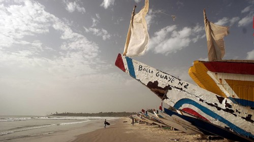 Decorative colorful boats on the beach with wide sky and sea in the background, Cap Skirring,