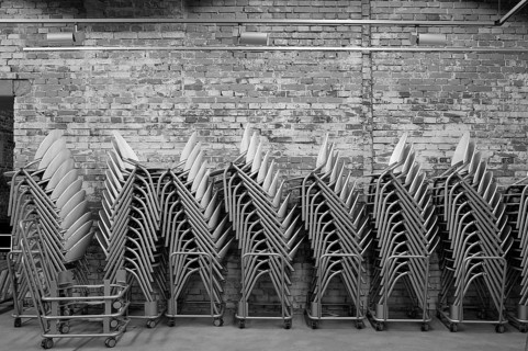 Modern stacking chairs in front of a brick wall, unfinished small hall of the NS Congress Hall from