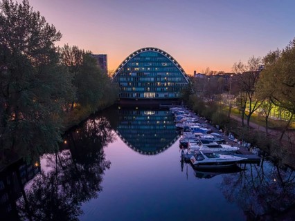 Aerial view of BBCC Berliner Bogen Conference Center at blue hour with Bille flood basin in the