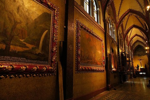 Interior of a Gothic-style church with decorated paintings and warm lighting, Cuenca, Ecuador